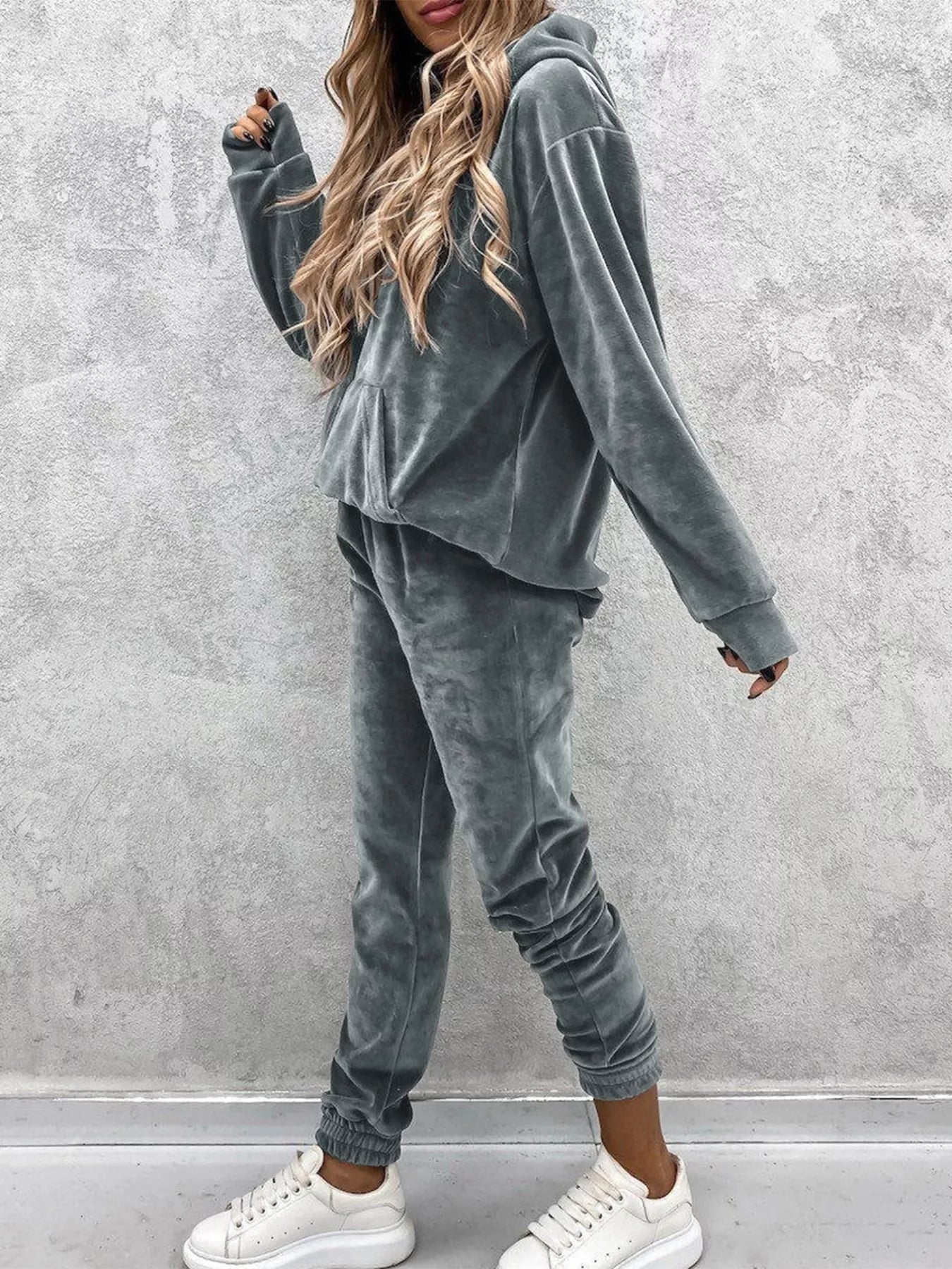 Hood up in misty morning light on women's kangaroo pocket hoodie pants set, shielding from chill while keeping style intact