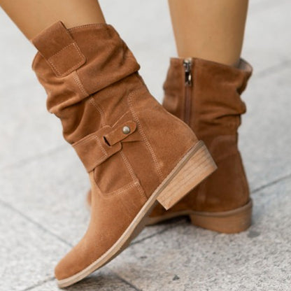 Model walking in brown pointed toe boots urban setting
