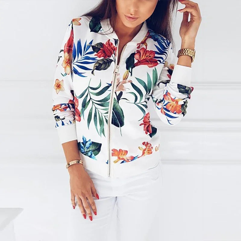 White floral zip jacket worn partly fastened, showing its red flowers, green foliage, silver zipper, and white ribbed edging.
