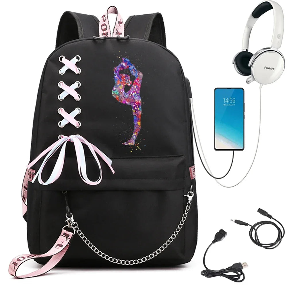 A black backpack featuring a colorful standing gymnast print, ribbon lacing, pink trim and chain, beside demonstration props.