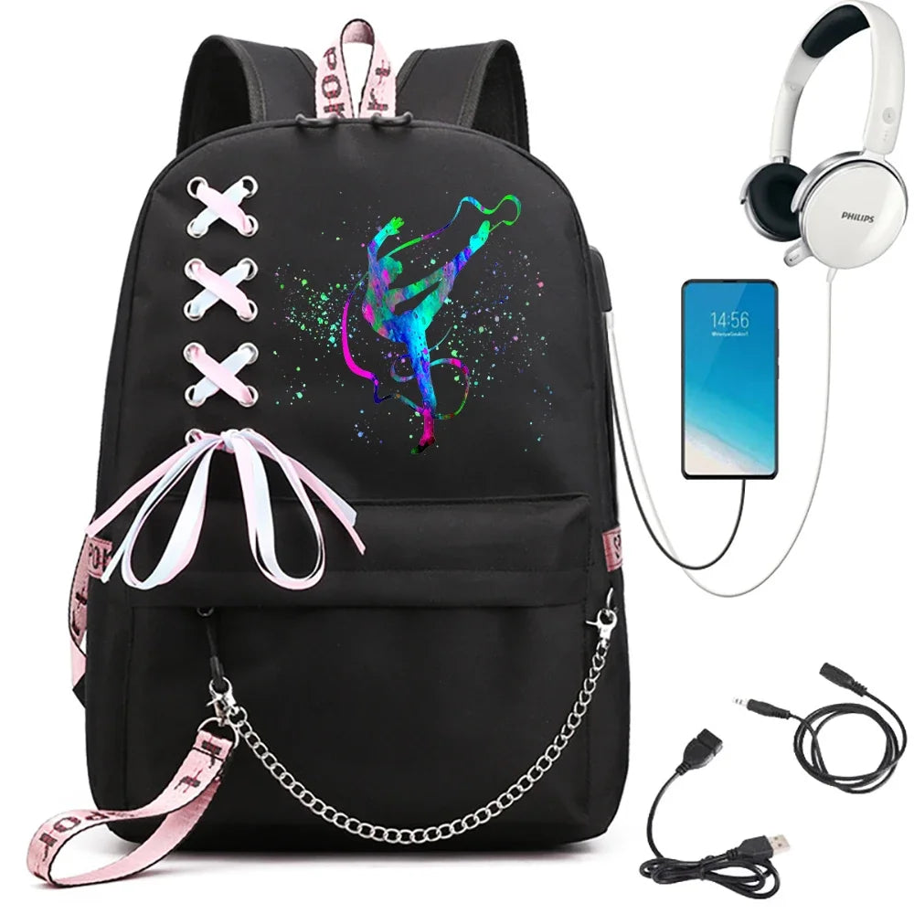 Black school backpack featuring multicolor gymnast print, pink ribbon lacing and chain, shown with phone and headphone props.