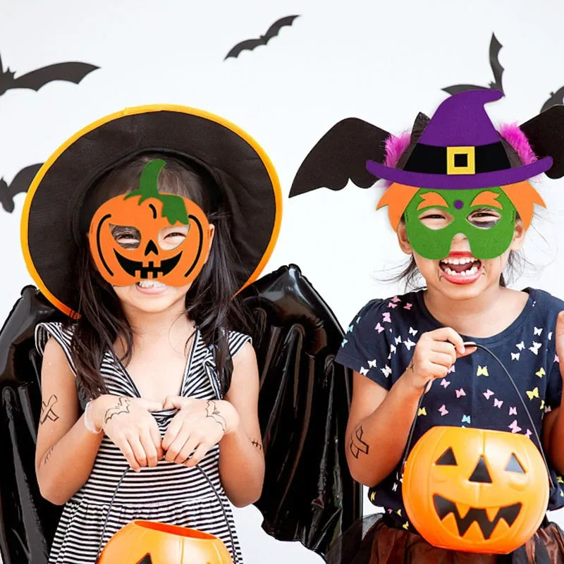 Two children wearing pumpkin and green witch costume masks, with a black hat and decorative bats for a Halloween party scene.
