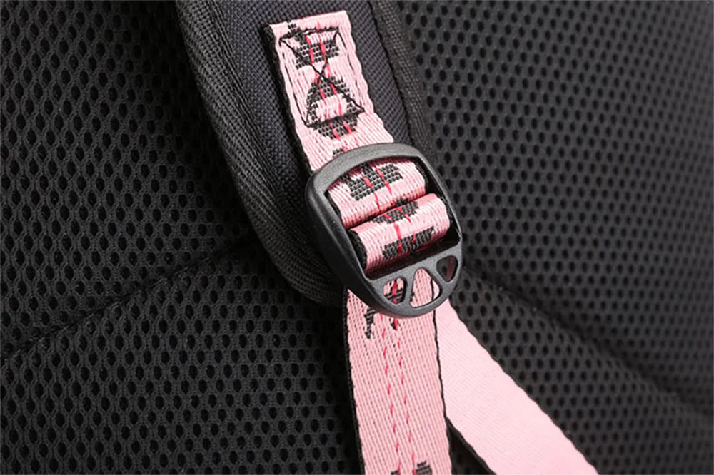 Close-up of black school backpack strap adjuster, pink SPORT webbing and mesh panel, showing visible construction in a photo.
