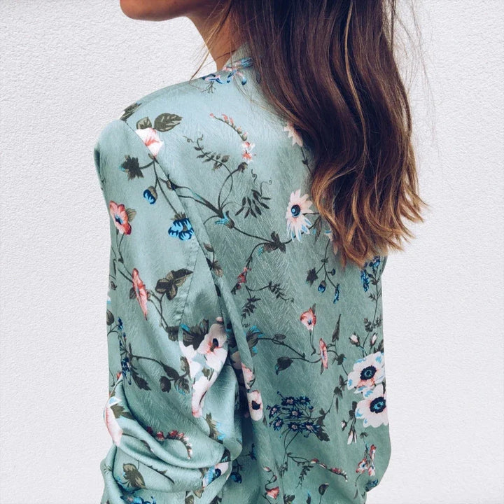 Back view of the Green printed jacket on a model, showing scattered flowers, long sleeves, a ribbed collar and matching hems.