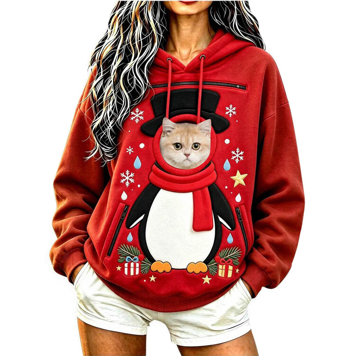 Model wearing a red penguin hoodie with a cat at the circular front opening, with a hood, long sleeves and black zip pockets.