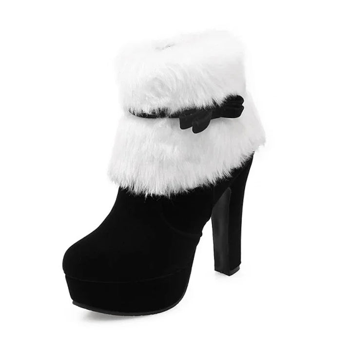 Single black boot on white background with a fluffy white cuff, matching bow strap, round toe, raised platform and high heel.