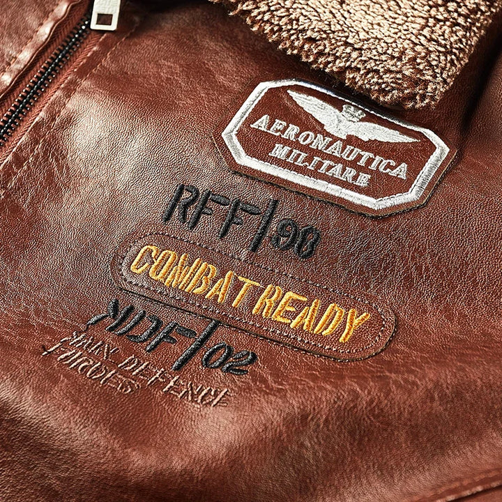 Close-up of chest lettering and a patch on the brown faux leather jacket beside the textured collar.