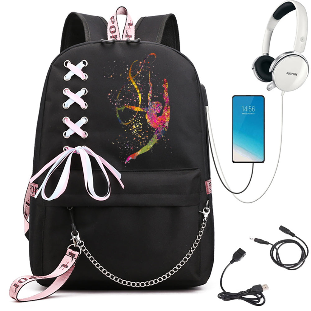 A black backpack featuring a bright inverted gymnast print, ribbon bow and chain, beside phone and headphone props in detail.