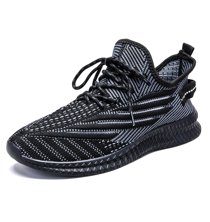 Black mesh sneaker shown alone on white, with patterned knit, black laces and a ribbed sole shown in the source photograph.