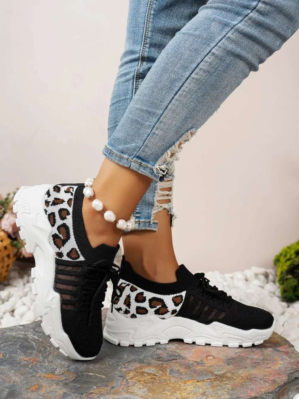 Stylish lace-up leopard mesh sneakers on white background

