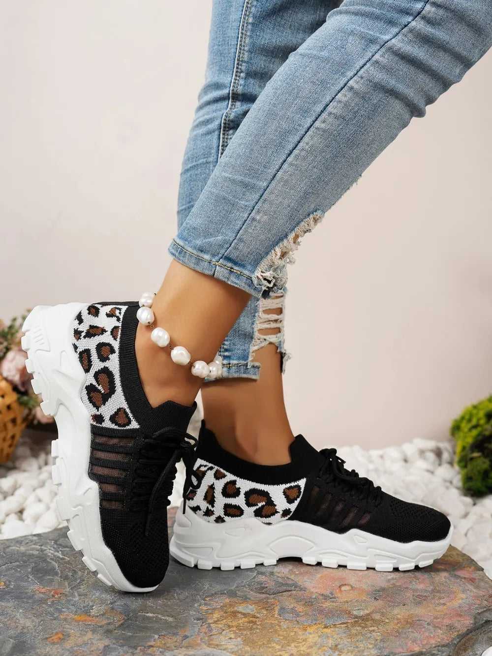 Stylish lace-up leopard mesh sneakers on white background

