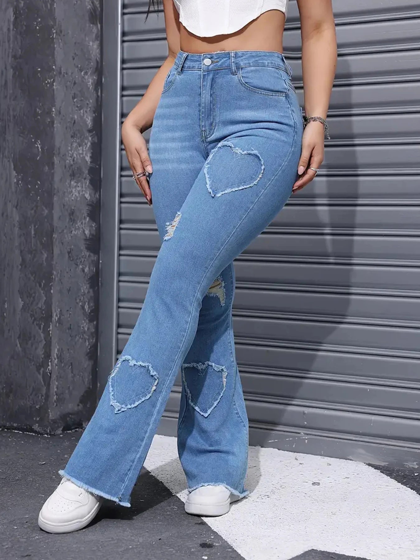 Side profile of slim fit distressed jeans showing high-waist design, belt loops, and natural drape of cotton-blend elastic denim fabric
