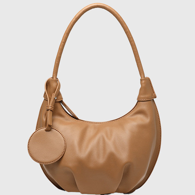Pink crescent shoulder bag, in PU leather with zipper closure, single strap and curved shape shown in a square product image.