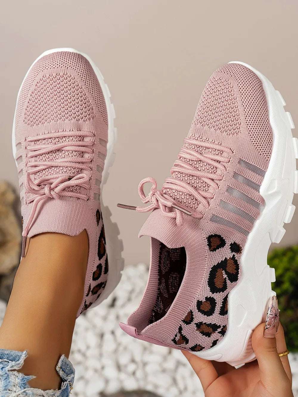 Closeup of leopard mesh sneakers laces and toe box design

