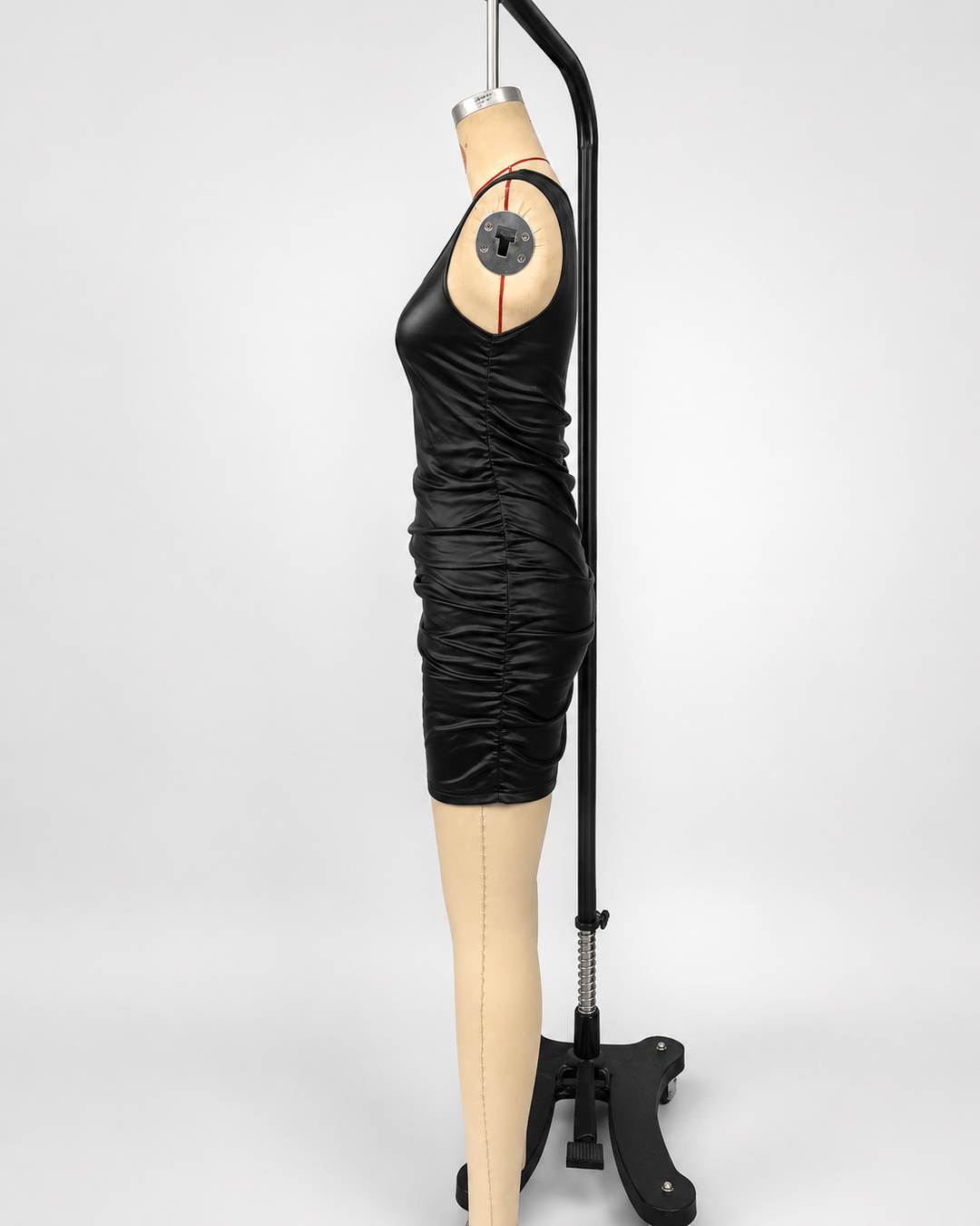 Sleeveless black mini slip dress with gathered side detail, smooth shine, and fitted evening style