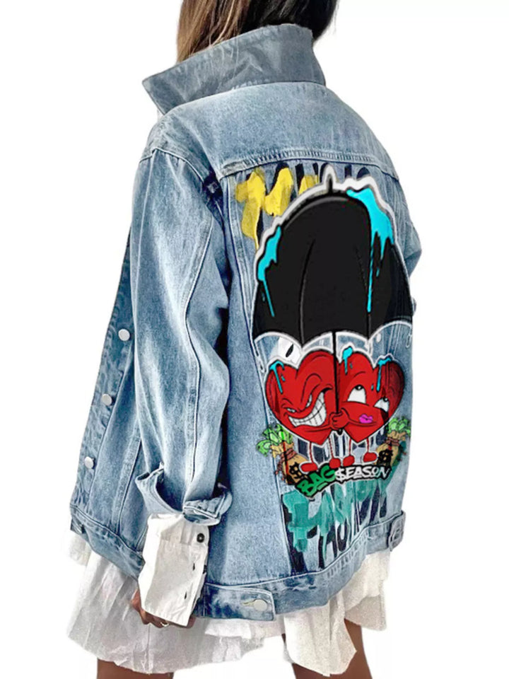 A light blue denim jacket with a large colorful graffiti-style graphic print on the back, shown on a model from the back against a white background.