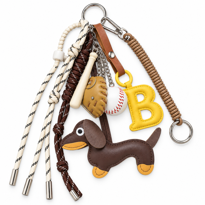 Top-down view of baseball bag charm set with yellow B and dachshund on a white background