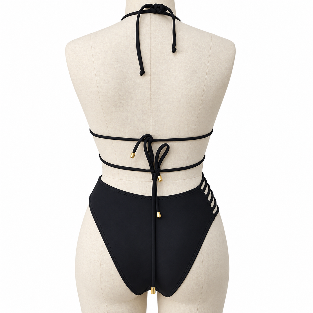Black bikini back tie detail on a display mannequin, showing the knots, cords and gold-colored tips against a white backdrop.
