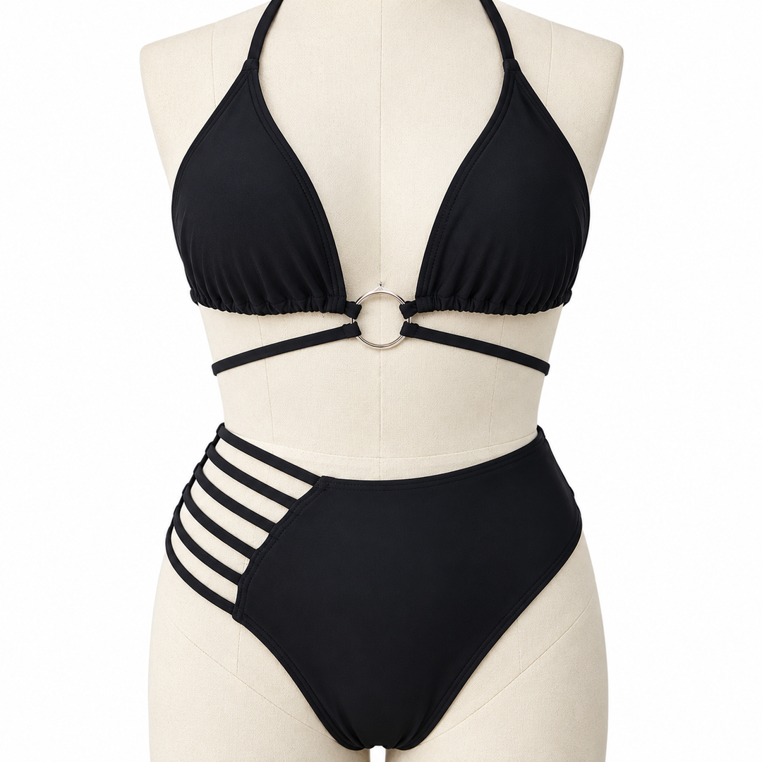 Black bikini front detail on a fabric display mannequin, showing the center metal ring, gathered fabric and underbust straps.