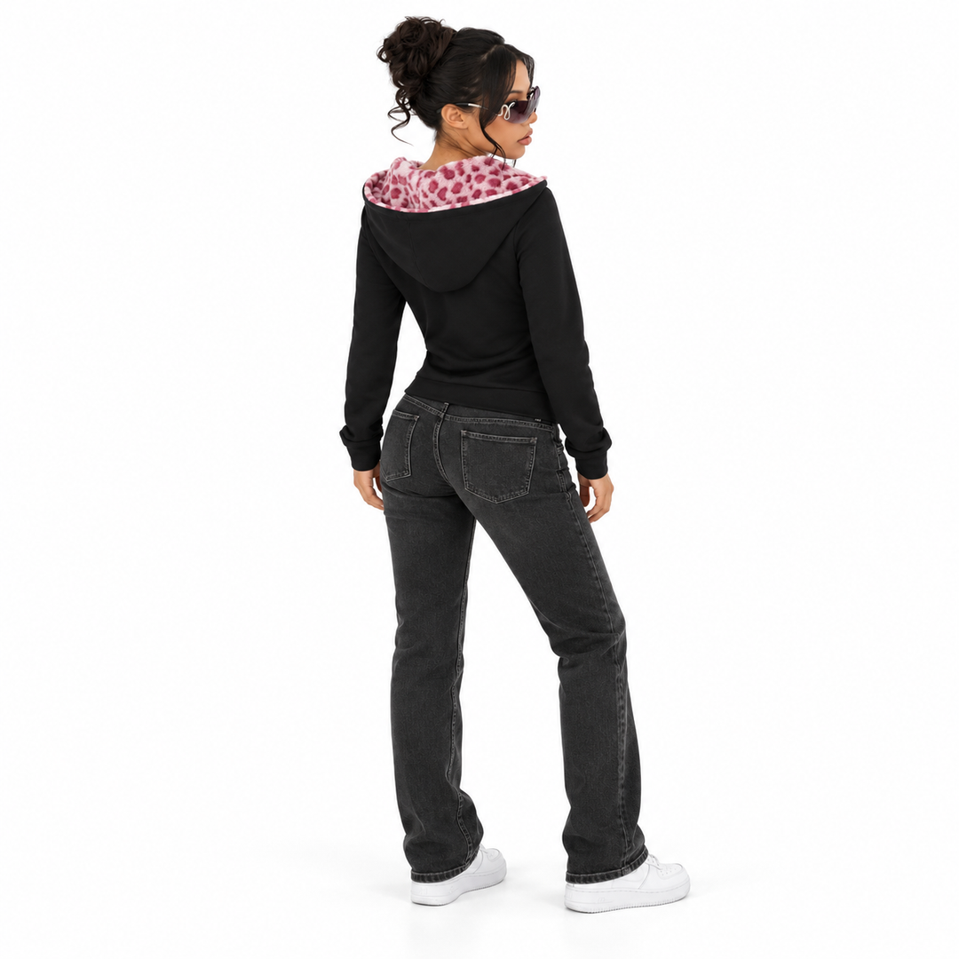 Rear view of a black fitted hoodie on a full-length model showing a plain back and lowered pink-lined hood in a white studio.