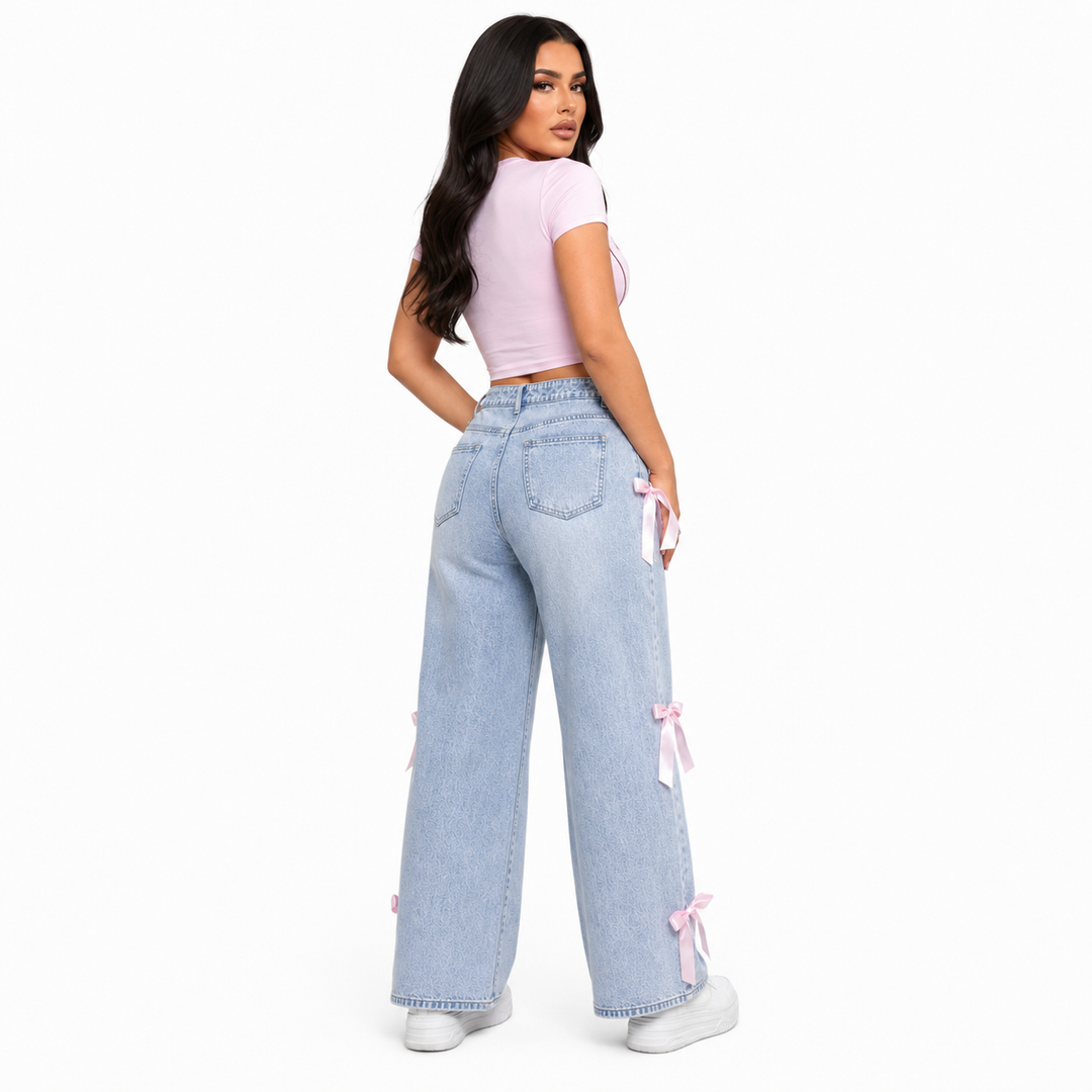 Light blue washed bowknot jeans for women with pink ribbon details, back studio view showing pockets and wide legs