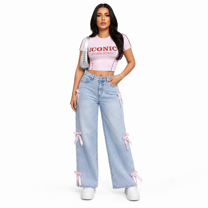 Bowknot jeans for women in light blue washed denim with pink ribbon details, front studio view on white background