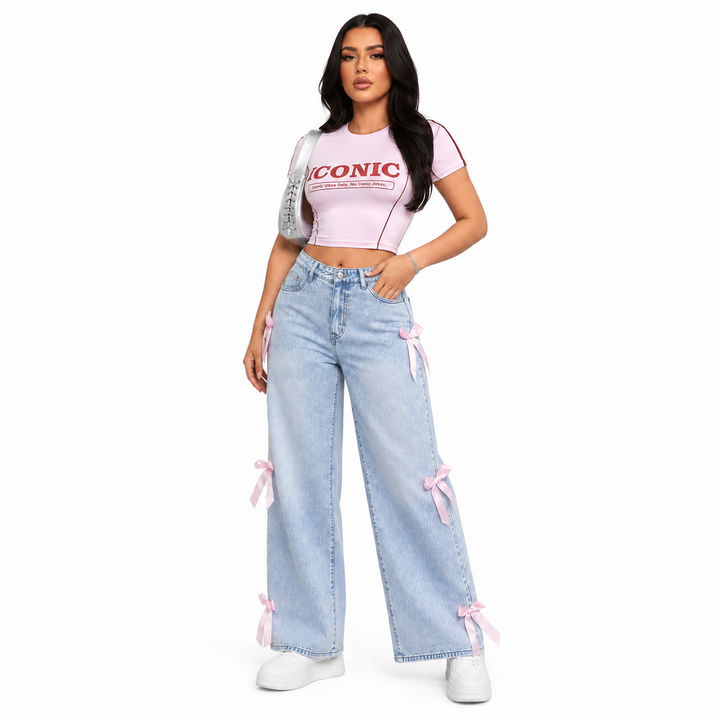Light blue bowknot jeans for women with pink ribbon accents in a clean three-quarter studio fashion view