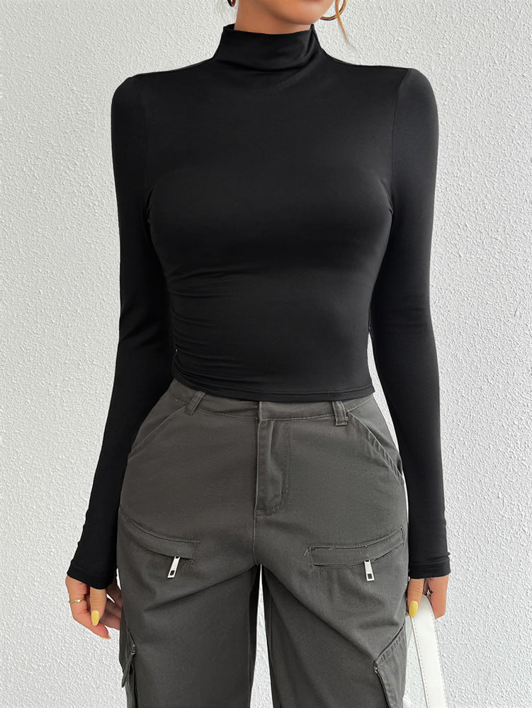 Person wearing a black turtleneck and gray cargo pants against a light gray background