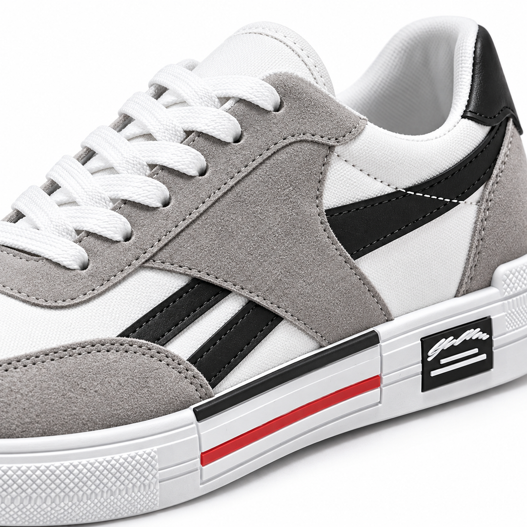 Close-up of black striped canvas shoes showing gray overlays, white laces, stitching and textured white sole detail.