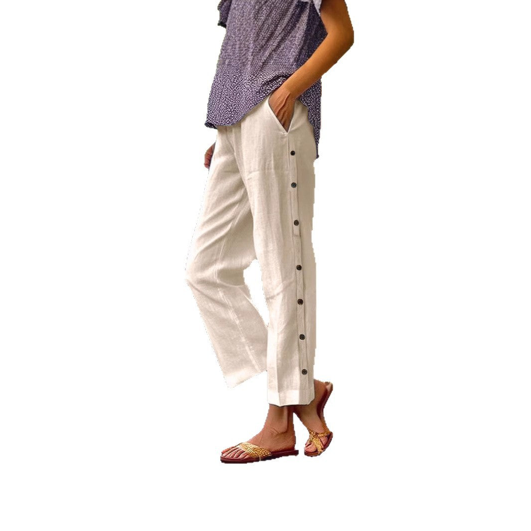 Person wearing white pants with black buttons on a white background