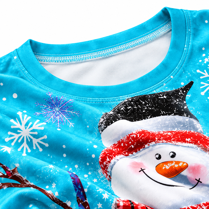Close-up detail of the aqua Christmas snowman shirt showing the neckline stitching, printed snowflake artwork and garment surface.