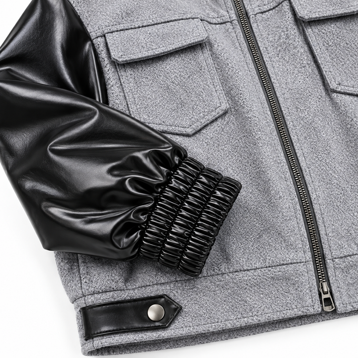 Close-up of black ruched cuff, glossy sleeve, gray hem and zipper detail
