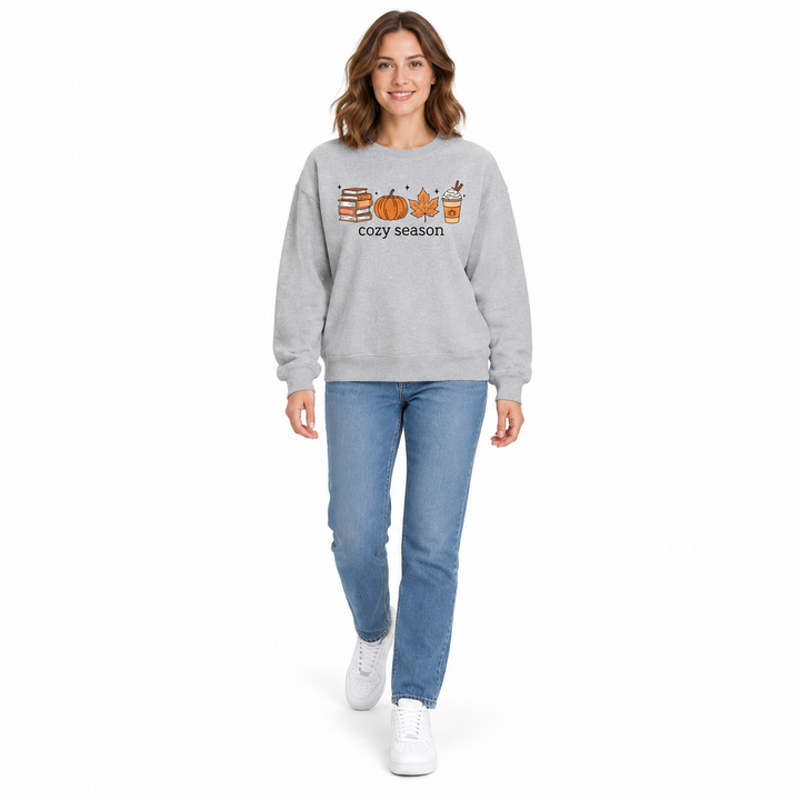 Gray sweatshirt on a full-length woman in jeans and white sneakers, showing the books, pumpkin, leaf and latte front graphic.