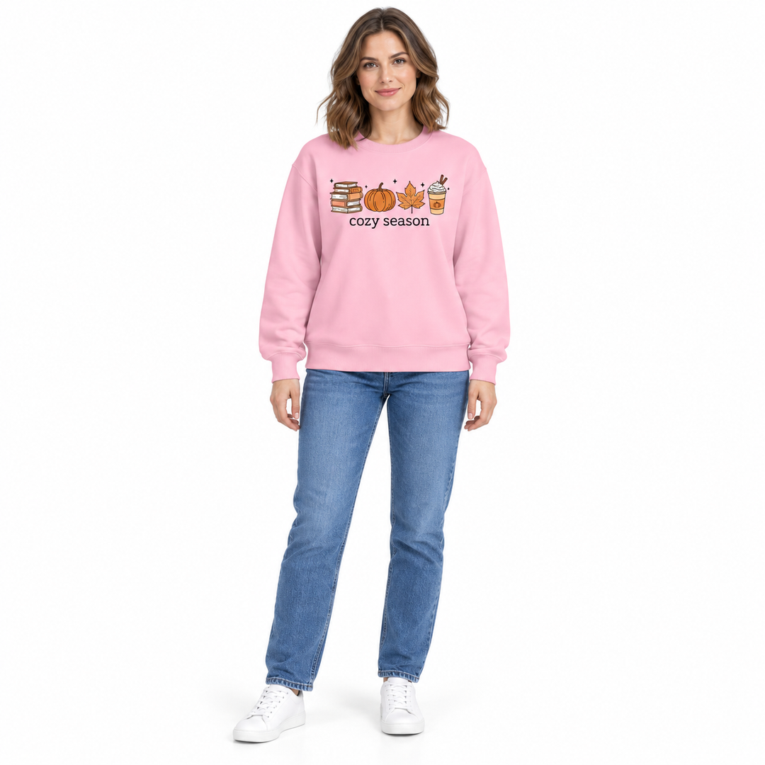 A pink crewneck sweatshirt on a full-length woman with blue jeans and white sneakers, displaying the cozy season autumn print