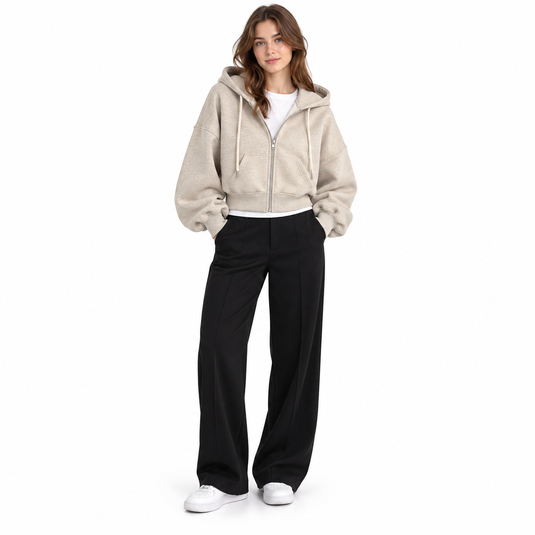 Photograph of cropped zip up hoodie in beige, front view, with the garment clearly visible, against a plain white background.