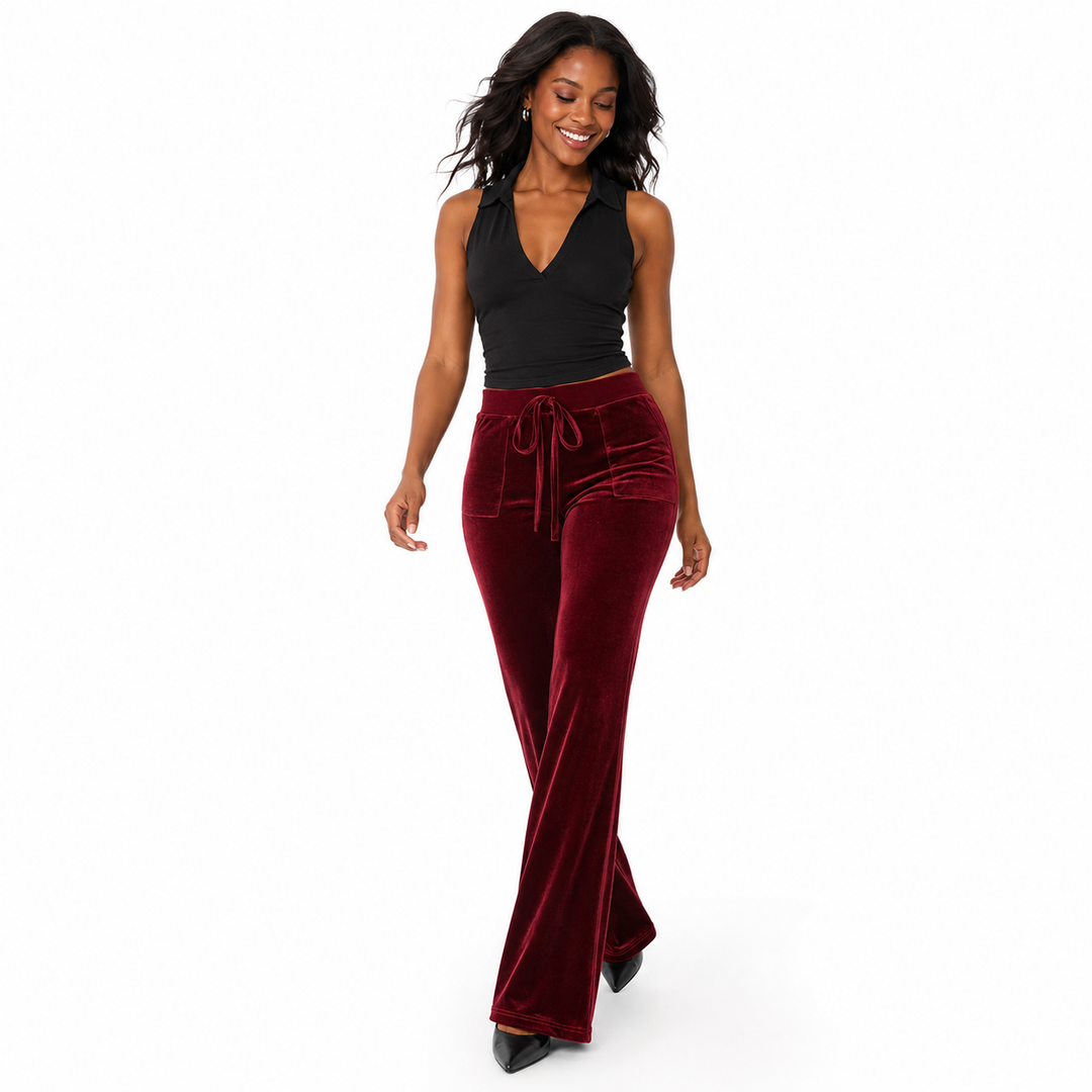 Side view of women flared trousers showing the smooth velvet texture shaped upper fit and leg-lengthening bootcut silhouette.