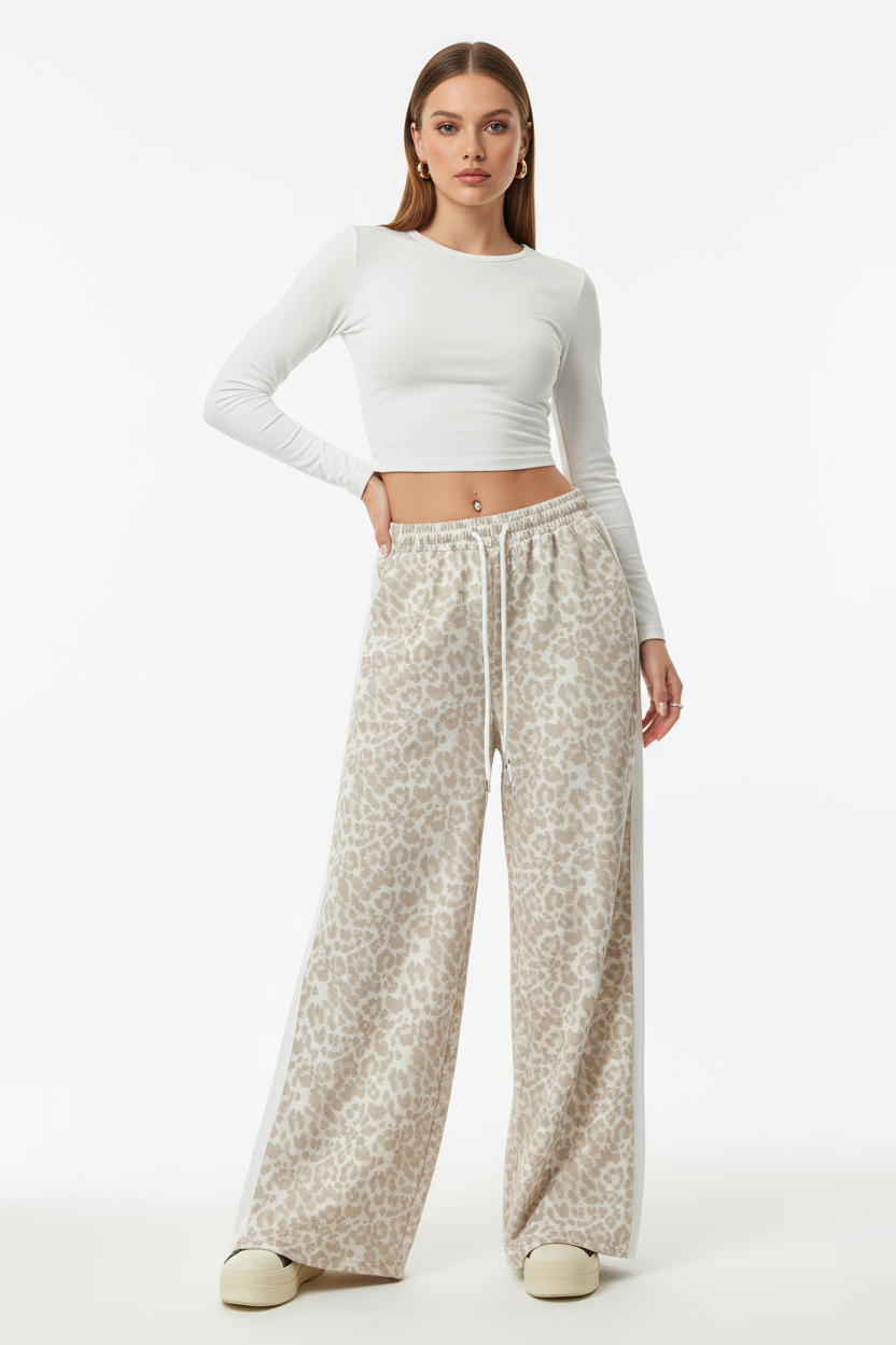 Model wearing leopard patchwork wide-leg pants with relaxed drape on a clean white studio background