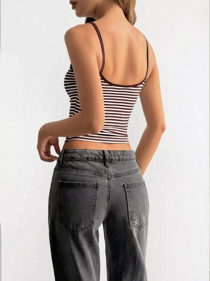 Person wearing a striped tank top and gray pants on a white background