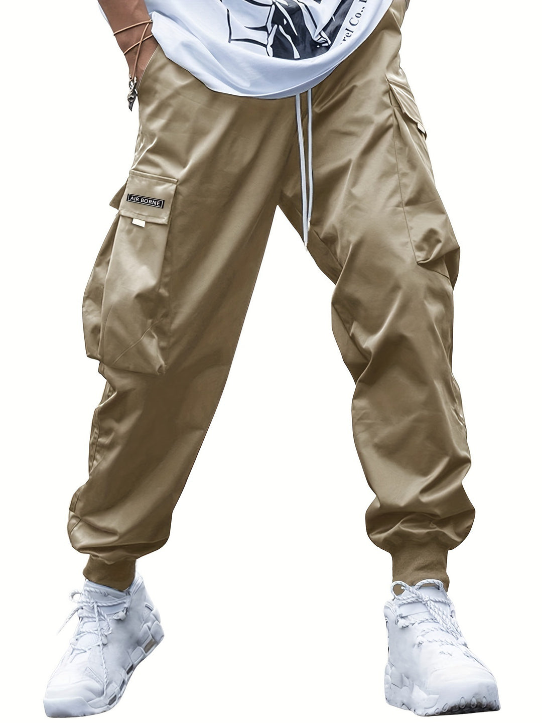 Beige cargo pants worn with a white shirt and white sneakers on a white background