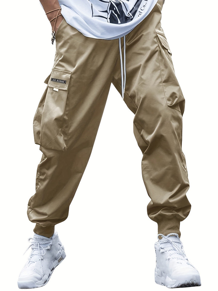 Beige cargo pants worn with a white shirt and white sneakers on a white background