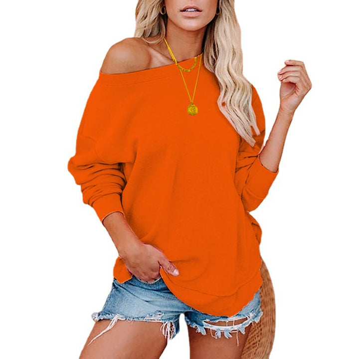 Woman wearing an orange off-shoulder top and denim shorts on a white background