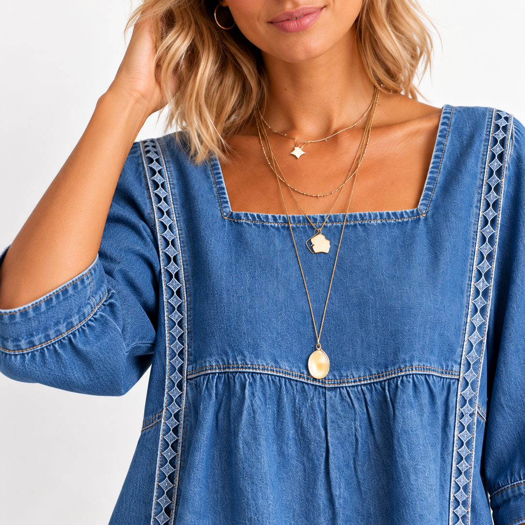 Closer model view of the denim blouse highlighting the square neckline, gathered front seam and lace patchwork detail.