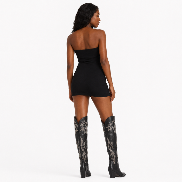 Black denim thigh high Western boots for women shown from the back on a professional model against a white studio background.