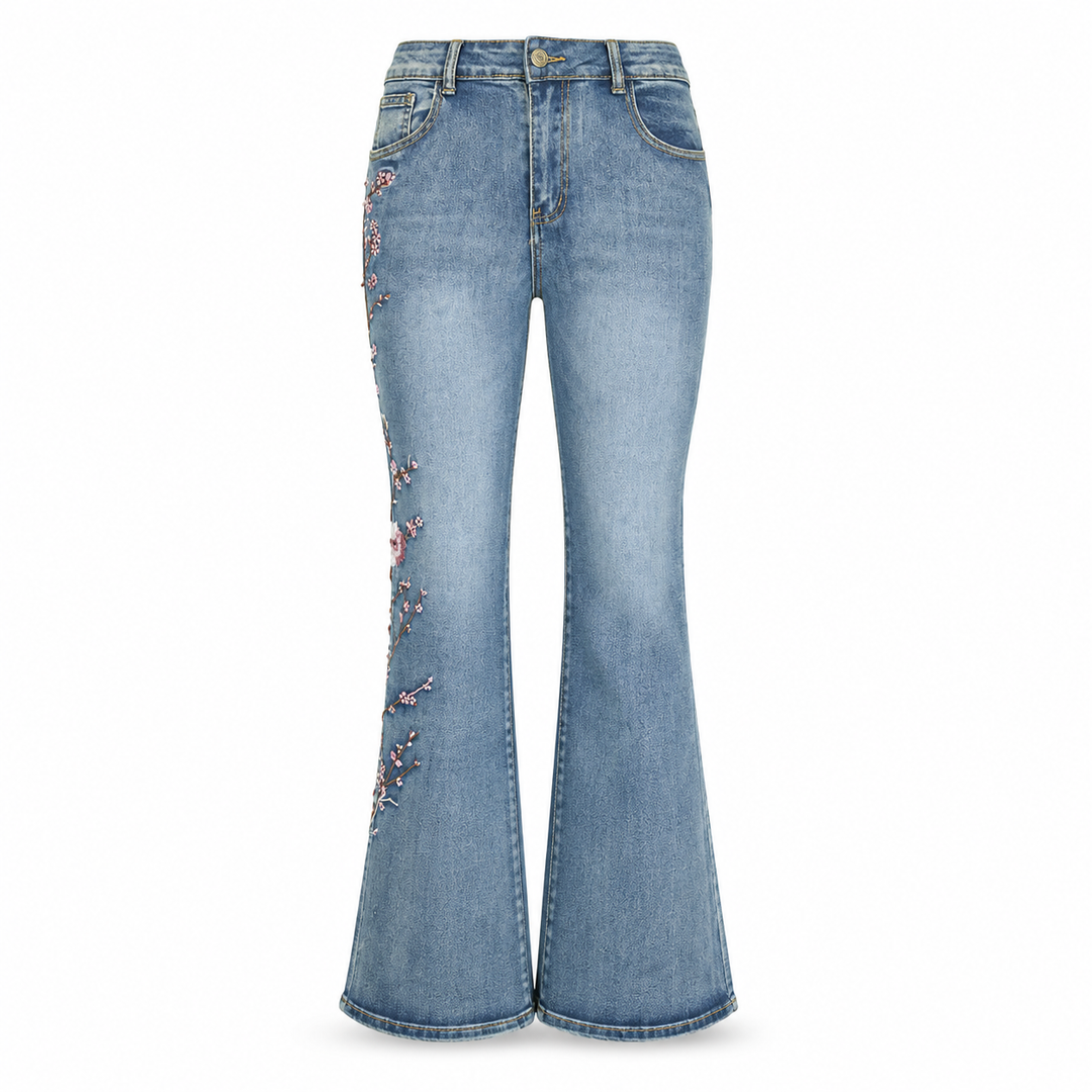 Light blue embroidered flared jeans with front pockets, zipper closure, high waist and pink floral outer-leg design on white.