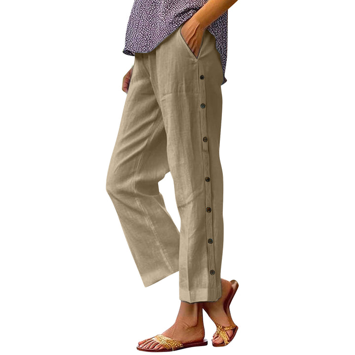 Beige pants with button details worn by a person on a white background