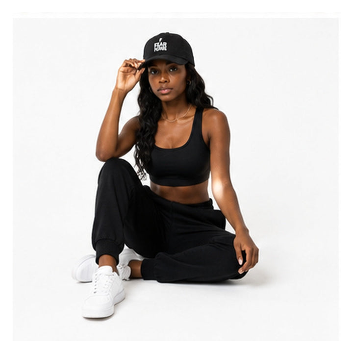 Fear None black denim cap styled on female model in relaxed studio pose