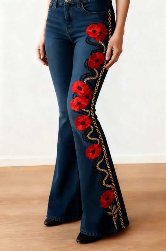 Dark blue slim-fit flared jeans with red poppies and a black and gold-tone vine print down one leg.