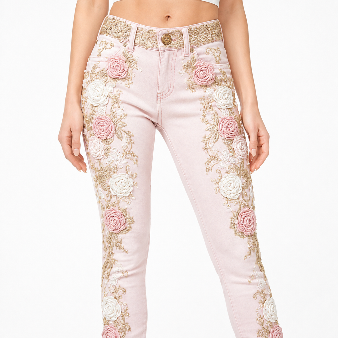 Close-up of pink floral embroidered jeans with raised rose appliques, gold vines, waistband and stitching