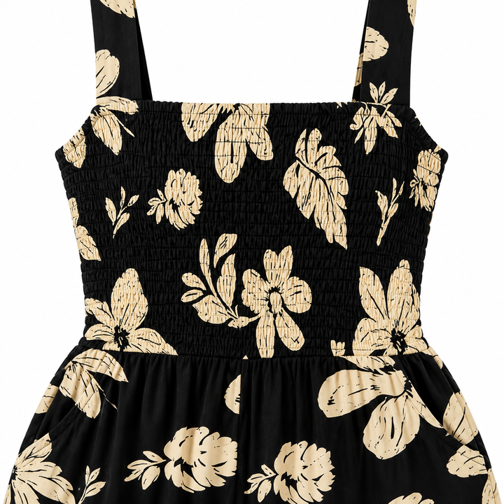 Close-up of smocking and cream botanical print on the black bodice.