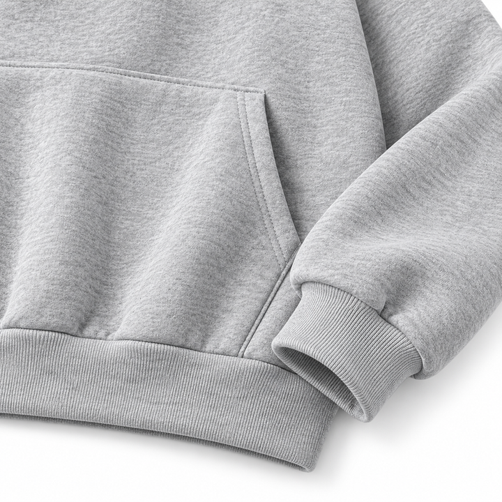 Close-up of gray hooded pullover showing front pocket, cuff and fabric surface